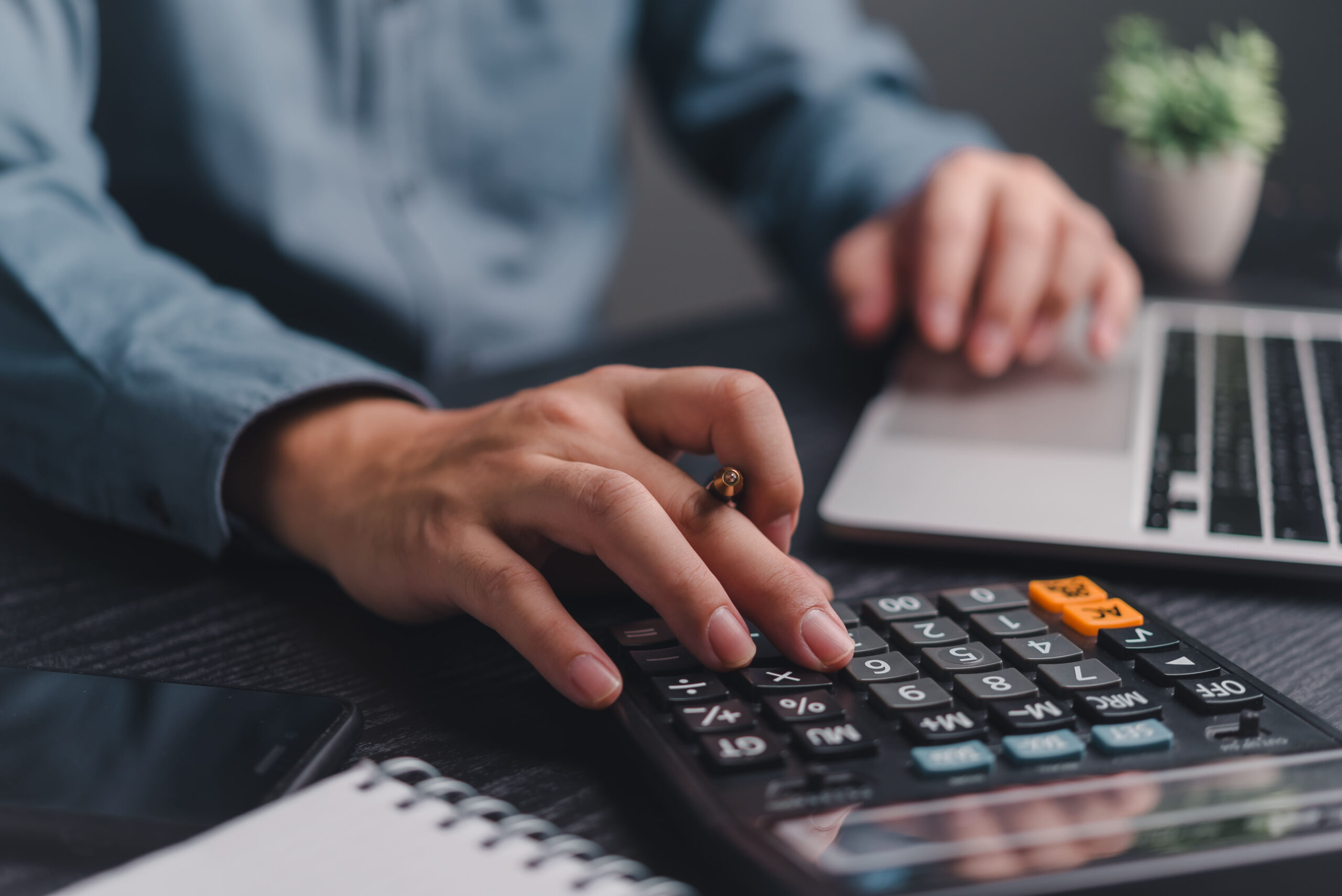 istockphoto-2152025654-2048x2048 Businessman using calculator bookkeeping payroll and budget tax. Business document finance accounting investment