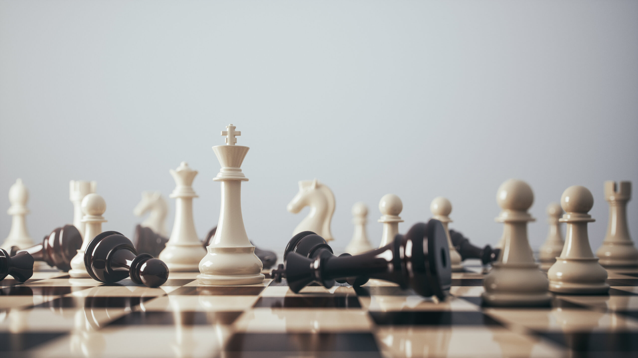 Depiction of chess pieces on a chessboard, highlighting a victorious white king surrounded by fallen black pieces, illustrating strategic success and competitive dominance.